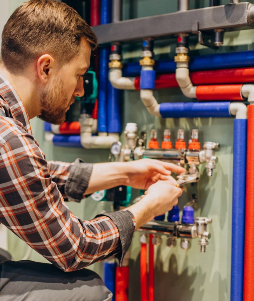 a plumber using a wrench on pipes