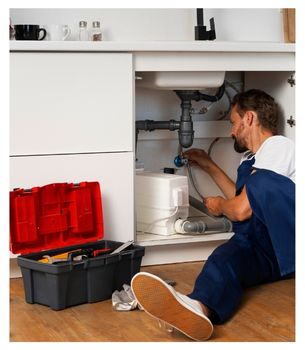plumber working under sink